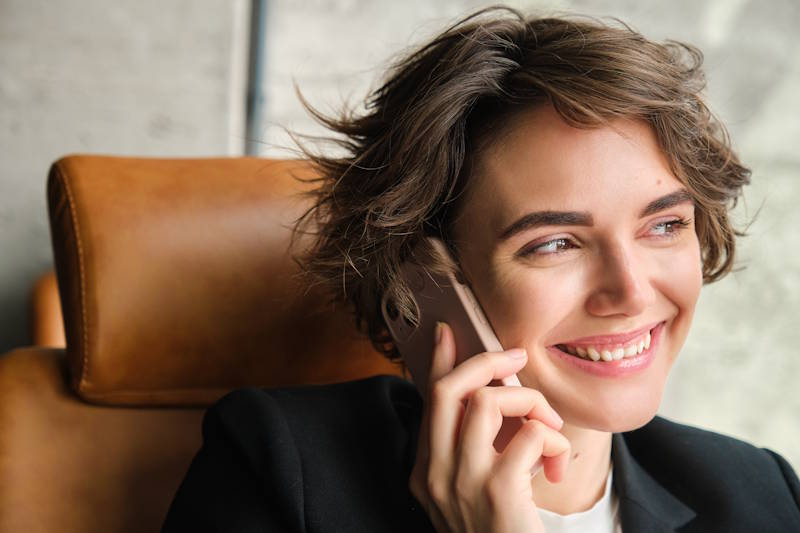 Femme souriante au téléphone, heureuse de parler à son partenaire malgré la distance