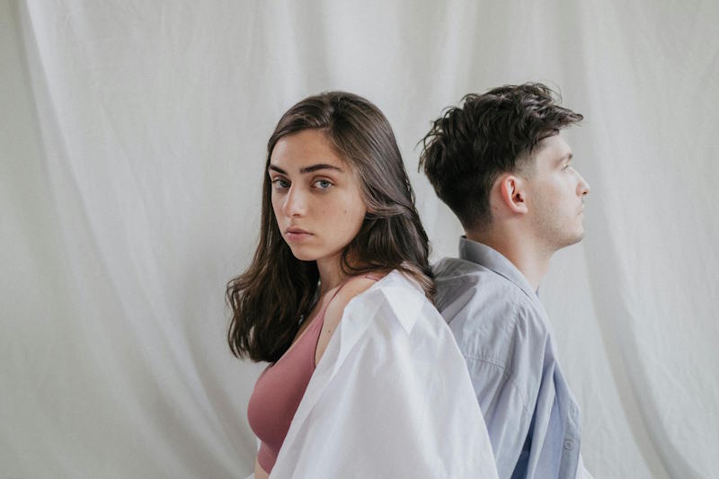 Couple assis dos à dos, symbole du manque d’écoute et de distance émotionnelle dans la relation amoureuse