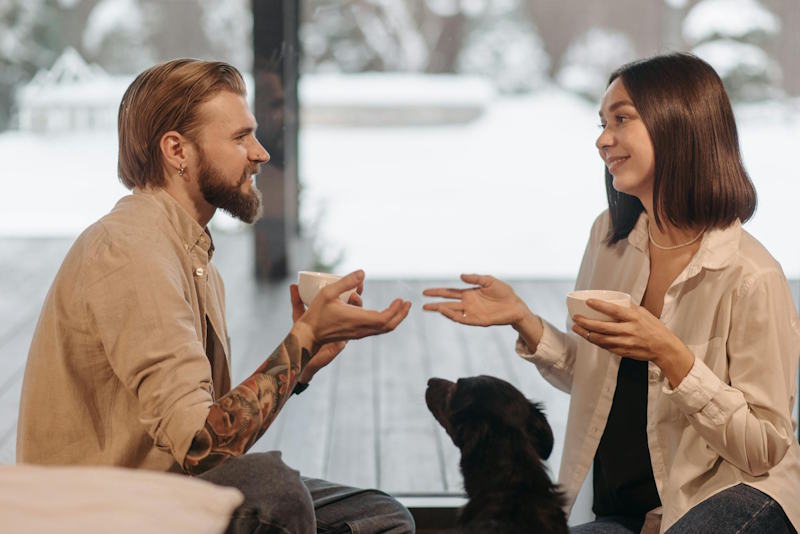 Couple discutant avec bienveillance autour d’un café, symbole d’écoute et de dialogue retrouvé dans la relation de couple